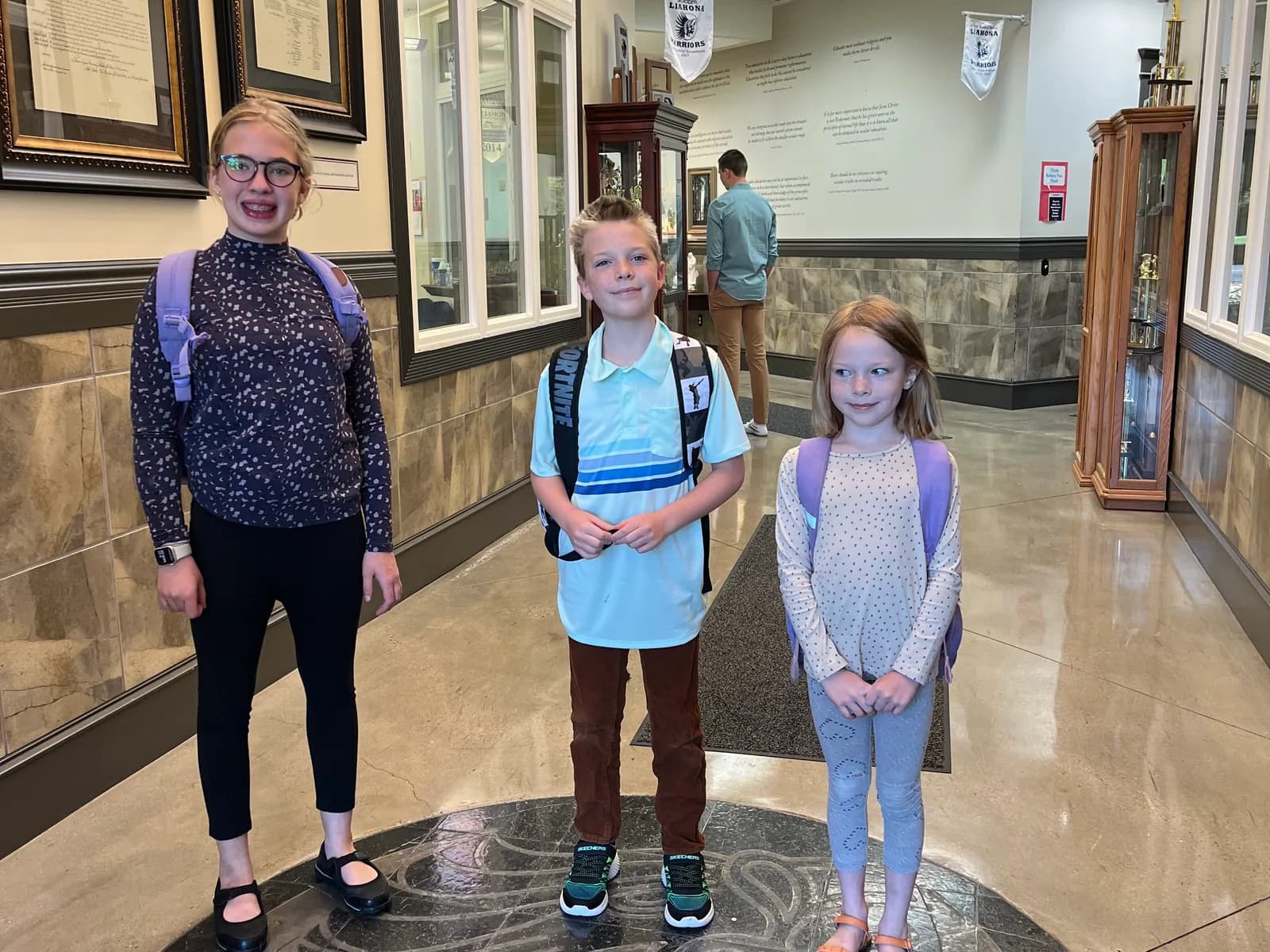 Students standing on the Liahona emblem in the school's main hall